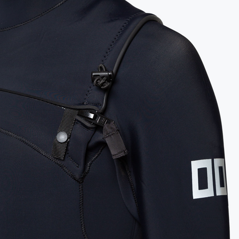 Close-up of the YKK AquaSeal zipper and protective snap guard on the shoulder of a 00 BY XIIIG wetsuit, showing the waterproof zipper pull and reflective 00 logo on the sleeve.