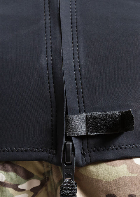 Close-up of a black YKK zipper on the lower back of the 00 BY XIIIG Shinobi 1mm wetsuit jacket, on a camouflage-patterned boardshorts