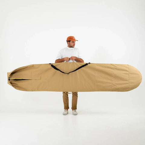 Man holding a large beige 10ft surfboard cover against a white background