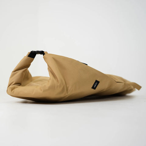 Tan surfboard bag laying on the ground showing the clasp and FARO logo at the end