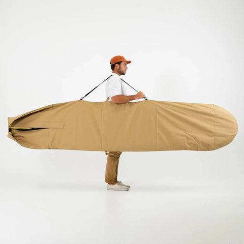 Man carrying a large beige 8ft surfboard bag on a white background