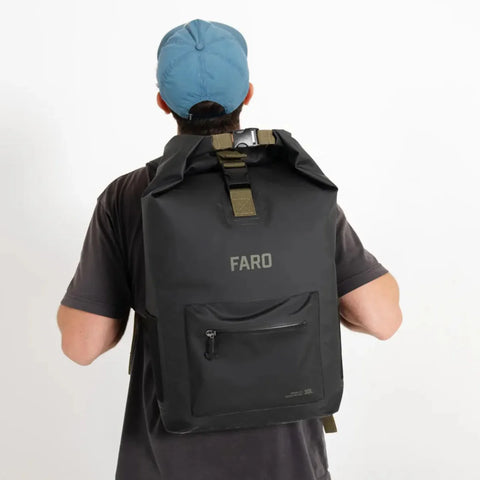 Person wearing a black backpack with 'FARO' branding on a white background