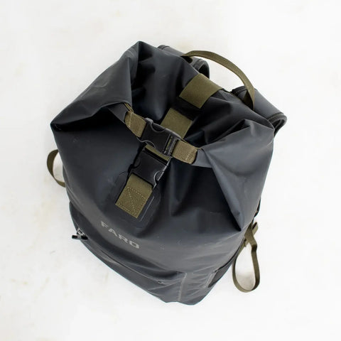 Black roll-top backpack with green straps on a white background