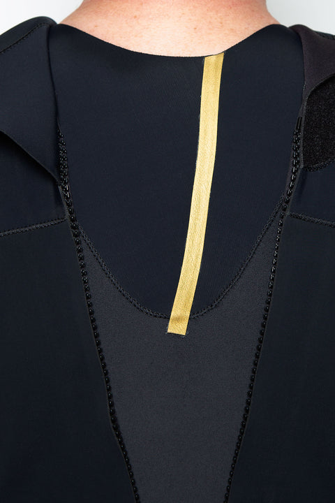 Close-up of a black wetsuit floodgate with gold taping on a white background