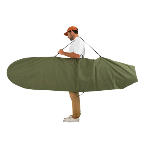 Man carrying a large green surfboard bag on a white background