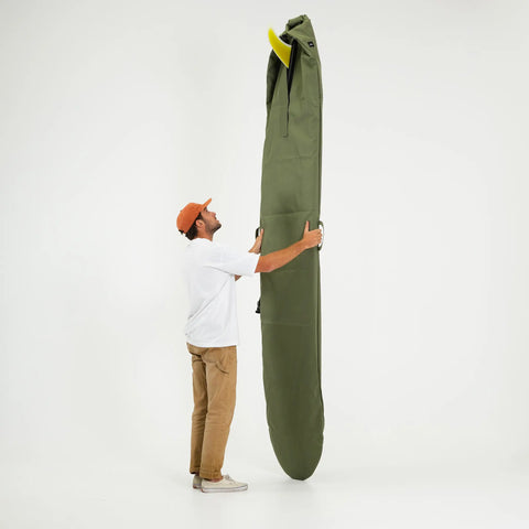 Person holding a large green surfboard bag with a longboard inside vertically against a white background