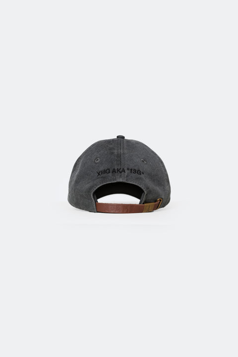 The back of the XIIIG Dad Hat in Charcoal with the words "XIIIG AKA "13G"" embroidered in black. You can also see the brown leather strap and bronze grommet.