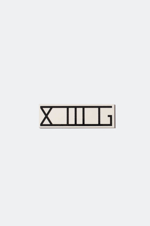 A black XIIIG sticker with a clear backing on a white background