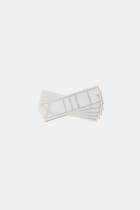 A stack of XIIIG stickers with silver shiny lettering and a clear backing - shot on a white background